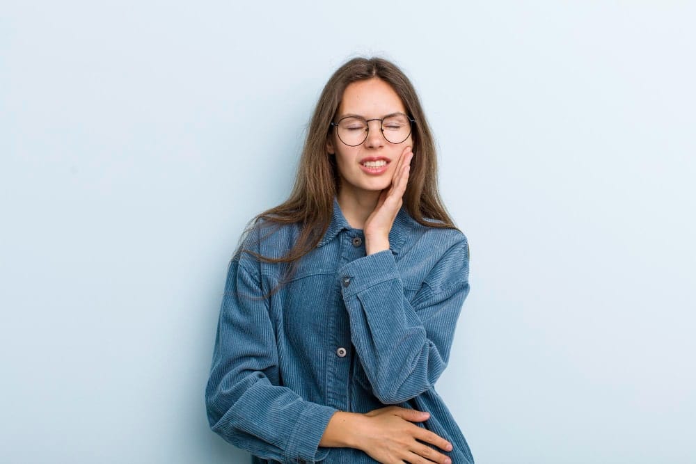 Image illustrating patient suffering from sensitive teeth pain treated by a dentist in Albania