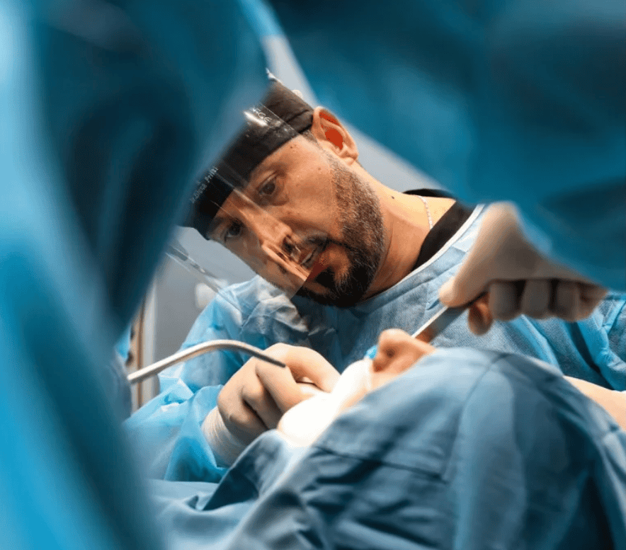 Oral surgery performed on sedated patient using suction and dental instruments.