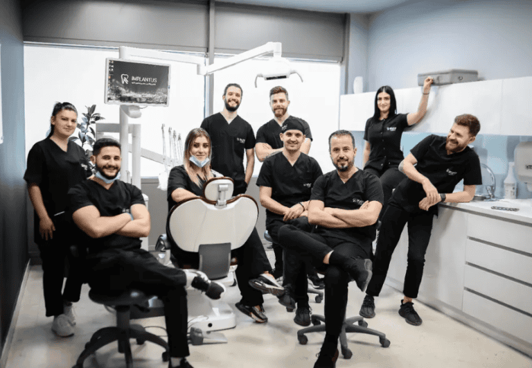Dentists and assistants pose around a dental chair in the treatment room