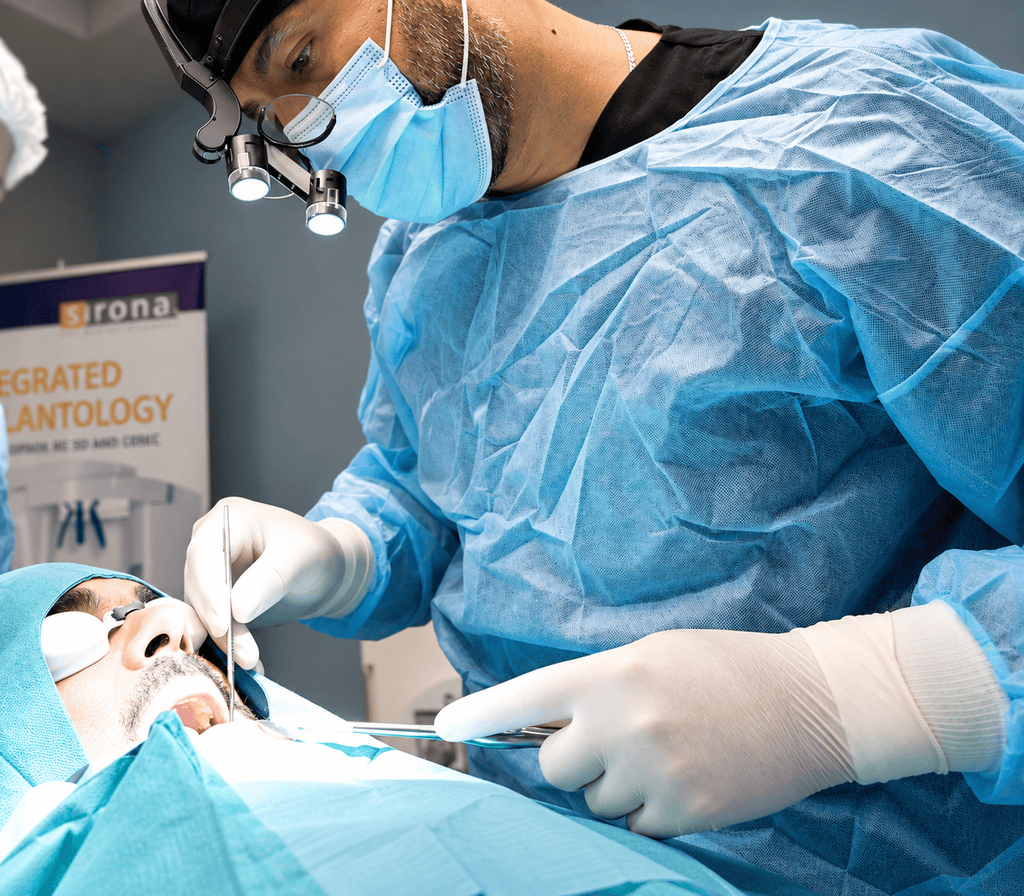 Un dentiste réalise un soin dentaire à l’aide de lunettes grossissantes et d’instruments dentaires.